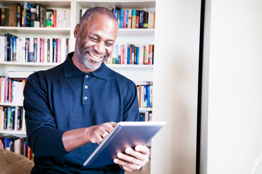 A person is on a tablet with shelves of books in the background, points to the Reader's Corner page.