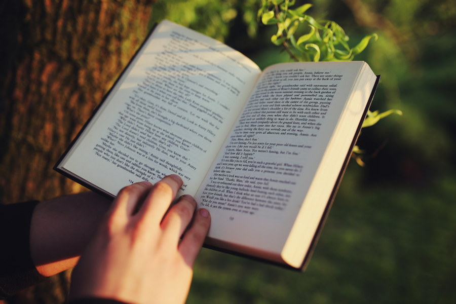 A person holds open a book, points to Suggest a Title form.