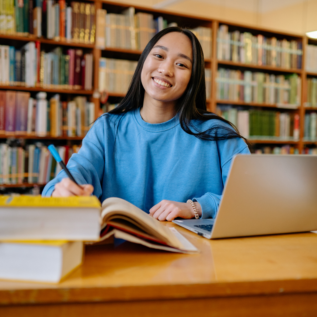 Teen doing school work in a library.