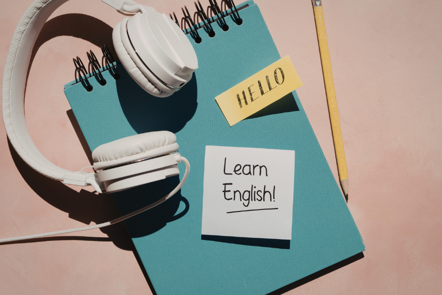 Headphones and a notebook, points to learning English page.