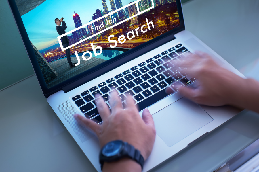 Person looking for a job on laptop, points to employment resources page.