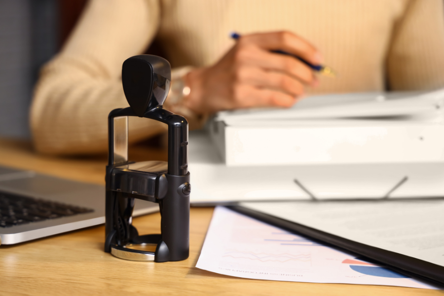 Person notarizing a document, points to notary public services.