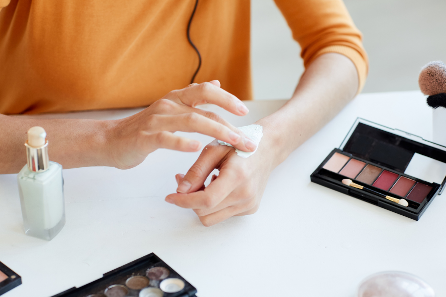 A person testing make up products, points to Consumer Reports.