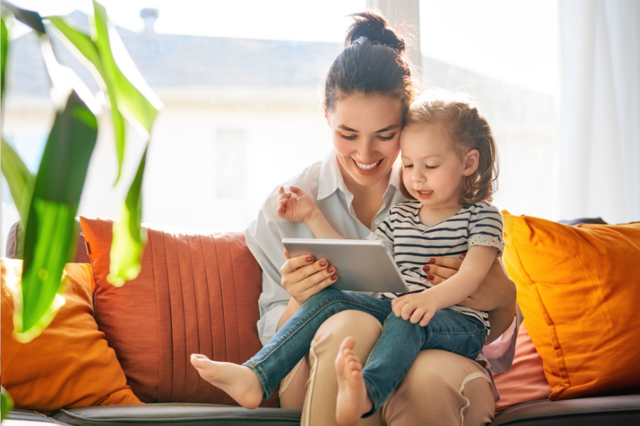 Mom and child reading a book on a tablet.