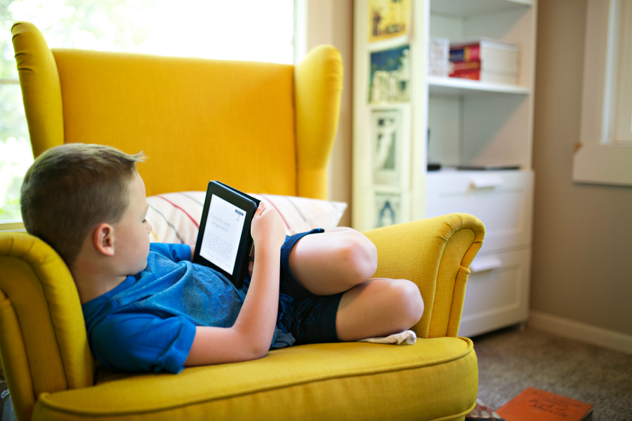 Child on tablet reading.