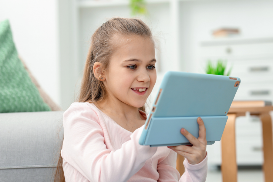 A girl reads from a tablet.