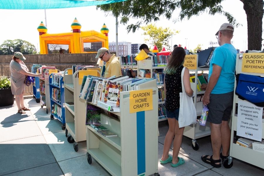 A group of people look at books at a book sale.